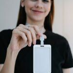 Portrait d'une femme joyeuse tenant un badge d'identification vierge, parfait pour la promotion d'une entreprise ou d'un événement.