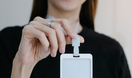 Portrait d'une femme joyeuse tenant un badge d'identification vierge, parfait pour la promotion d'une entreprise ou d'un événement.