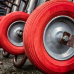 Roues rouges de chariots alignés sur un sol poussiéreux