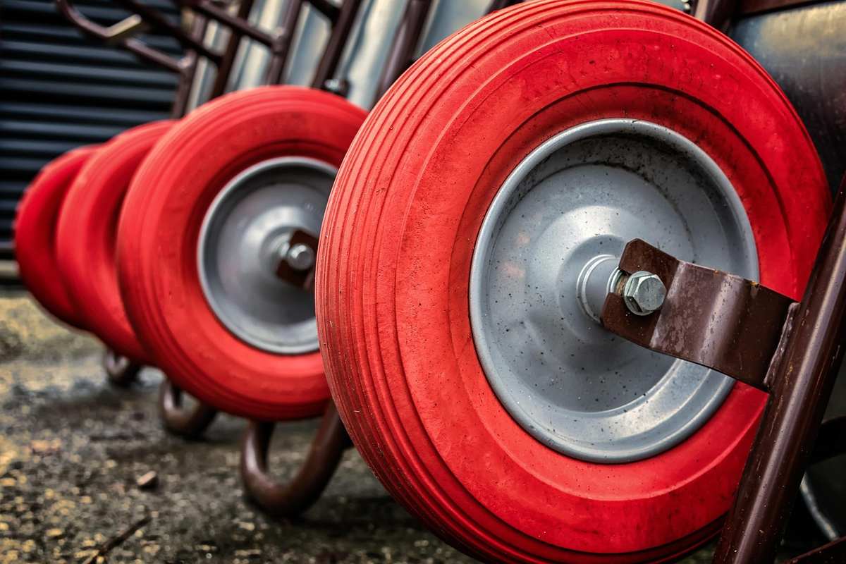 Roues rouges de chariots alignés sur un sol poussiéreux